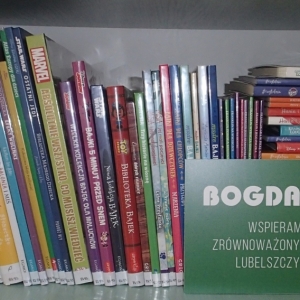 Kilkanaście nowych książek leżących na stole z napisem "Bogdanka. Wspieramy zrównoważony rozwój Lubelszczyzny"