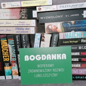 Kilkanaście nowych książek leżących na stole z napisem "Bogdanka. Wspieramy zrównoważony rozwój Lubelszczyzny"