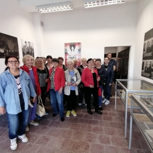 Stojący członkowie klubu dyskusyjnego "Seniorzy z książką na ty" w trakcie wizyty w Izbie Pamięci Żołnierzy Niezłomnych w Witaniowie