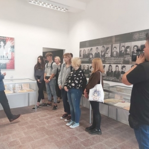 Stojący uczniowie wraz z ekipą telewizyjną TVP 3 Lublin w trakcie zwiedzania Izby Pamięci.