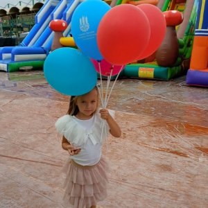 Stojące dziecko z balonem z logo PBP w Łęcznej.
